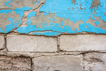 Concrete wall with old cracked blue paint. Texture and background