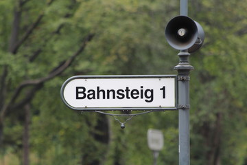 Schild Bahnsteig auf dem Bahnhof mit Lautsprecher
