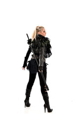 full length portrait of blonde girl wearing lack fantasy warrior outfit. standing pose wit bak to the camera. isolated on white studio background.