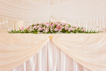 Wedding main table simple brigt floral decoration with pink flowers in bloom