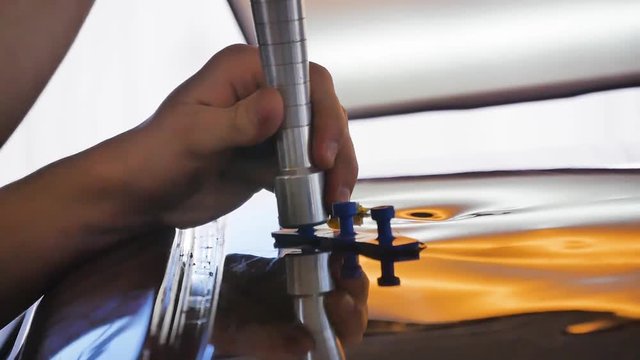 PDR technology. Repair car body. Remove dent from car