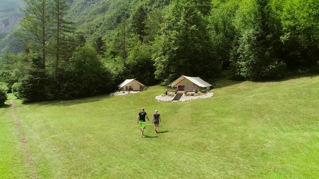 
Aerial view of couple walking to an outdoor sitting area at a camping site.