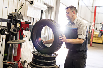 Mechanic changing car tire at work