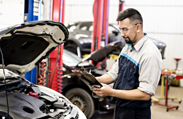 Handsome mechanic job in uniform working on car