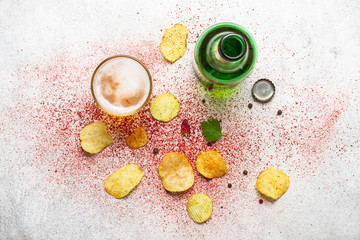 Beer and potato chips on a gray background