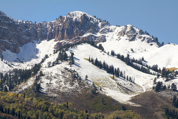 Utah Mountain peak near ski resort with snow capped peaks and fall leaves