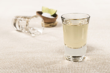 Authentic shot of Tequila Mexican traditional drink accompanied with lime and salt Tequila shot...