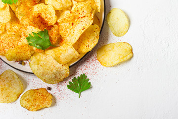 Crispy potato chips on a plate on a white background
