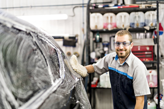 Man at work cleaning automobile at car wash