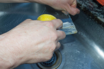 hand cleaning up pane with dish sponge