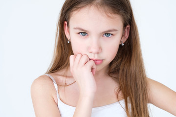 serious child thinking over something. hand under the chin. little girl portrait on white background. mood feelings personality and facial expression concept