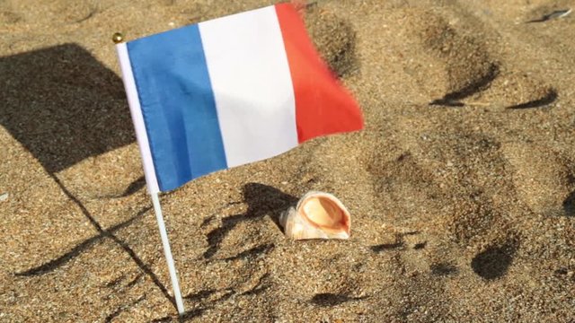 Flag of France on a sandy beach.