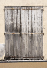very old weathered grey doors in ancient wall of medieval village in french provence