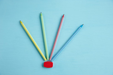 several multicolored pencils on a blue background