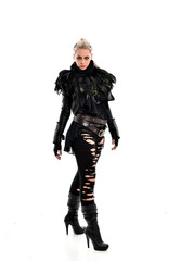 full length portrait of blonde girl wearing torn black feather costume. standing pose, isolated on white background.