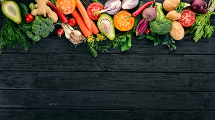 Zelfklevend Fotobehang Healthy food. Vegetables and fruits. On a black wooden background. Top view. Copy space. © Yaruniv-Studio
