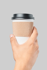 Mockup of men's hand holding white paper large size cup with black cover isolated on grey background