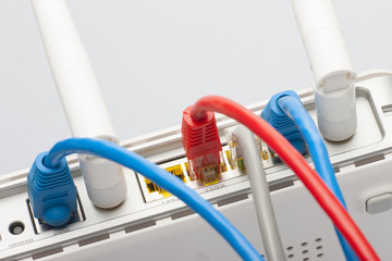 Modem router network hub with cable connecting. Bright blue and red cables and connectors.