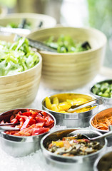 bowls of mixed fresh organic vegetables in salad bar display