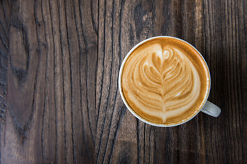 Latte art coffee cup on wooden table, Flat lay
