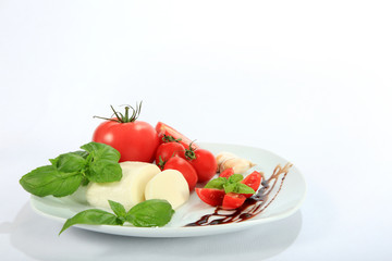 Mazzarella, pomidor, czosnek i bazylia na białym tle.