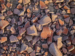 Roads: Closeup of an unpaved road that is surfaced with crushed old building materials
