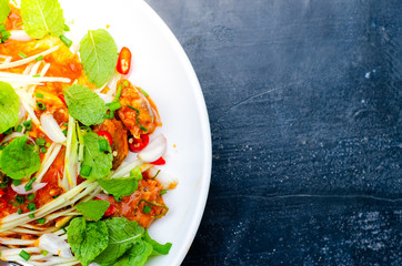 Spicy Canned fish salad and vegetable in white dish on retro background,Thai food style ,select focus.
