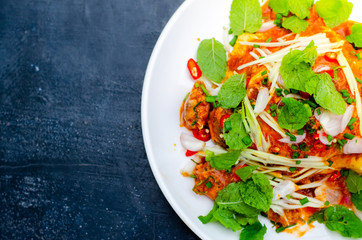 Spicy Canned fish salad and vegetable in white dish on retro background,Thai food style ,select focus.