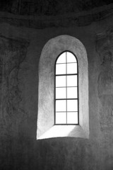Ancient thick walled monastery / church window niche with wooden bench and diffuse indirect light.