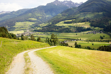 Fototapeta na wymiar Beautiful lush green Austrian alp valley meadows landscape and hiking trails in the Zell am See area.