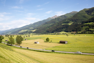 View on the Mittersiller Strasse road connecting the villages of Mittersil and Zell am See with cars and valley meadows.