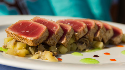 Delicious plate of red tuna medallions along with potatoes, onion and apple jam. Tasty non vegetarian dish, healthy eating, gourmet concepts