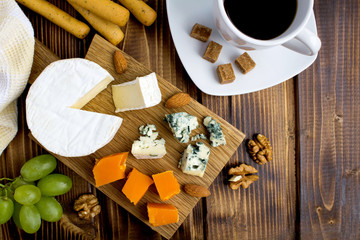 Snack  with cheeses and bread sticks on the brown  wooden background.Top view.