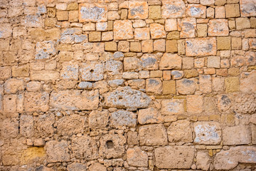 ancient weathered brown wall limestone like background in Malta, close up