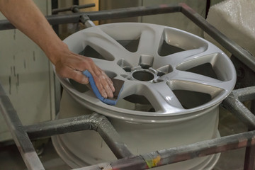 Master body repair man is working on preparing the surface of the aluminum wheel