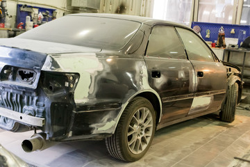 The black car in the body of the sedan is prepared for painting