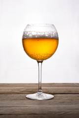 Copa de cerveza con fondo blanco y mesa de madera