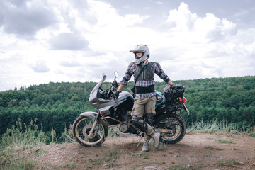 Fototapeta na wymiar Adventure motorcycle, Motorcyclist gear, A motorbike driver looks, concept of active lifestyle, enduro travel road trip