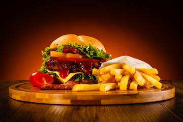 Tasty burger with chips served on cutting board