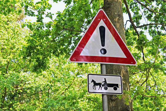 traffic sign warning about crossing horse carriages in a forest