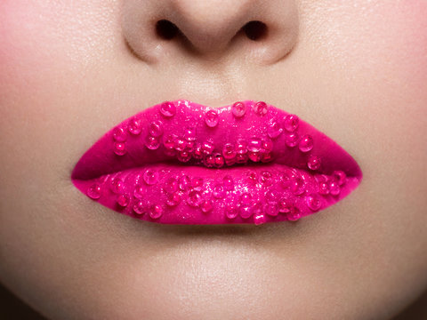 Sexual full female lips open. Pink color of lipstick on lips. Creative New Year's make-up. Fashionable image. Brilliants
