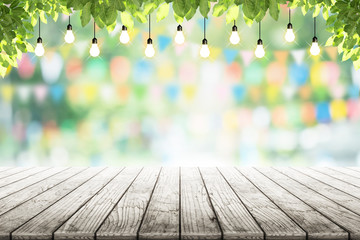Empty wooden table and bulbs within party in garden background blurred.