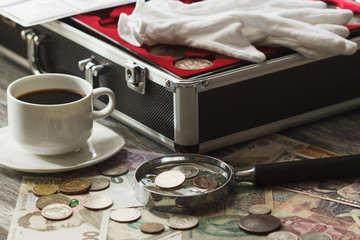 Coins and banknotes, magnifying glass and box for coins