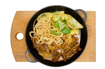 Lunch from roasted meat of varnish and potatoes in a black frying pan on a wooden kitchen board. View top. Isolated on white background
