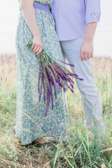 Cute couple in love hugging in a field of flowers, cropped