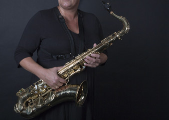 Obraz premium Vrouw houdt saxofoon schuin vast