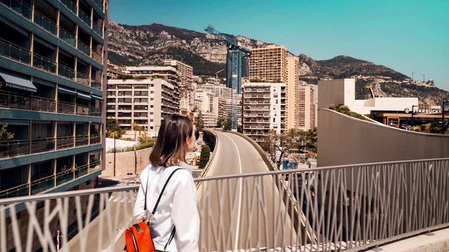 Young woman walking on a bridge in Monte Carlo, Monaco on a sunny day