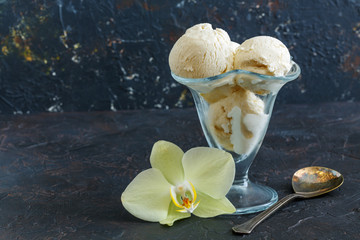 Vanilla ice cream in a vase and an orchid flower.