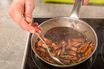 fried vegetables with meat in a frying pan