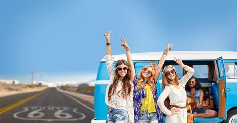 Poster road trip, travel and people concept - happy young hippie friends having fun and dancing at minivan car over us route 66 background © Syda Productions